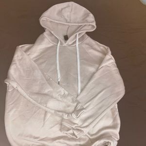 An XS beige hoodie with the writings “love never fails” on the backside